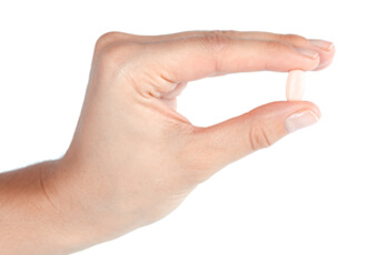 Hand mit Tablette gegen Nagelpilz